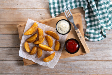 Fried potato wedges with sauces isolated on white background. Top view