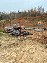 construction, building materials stacked behind a fence, stacked tubes