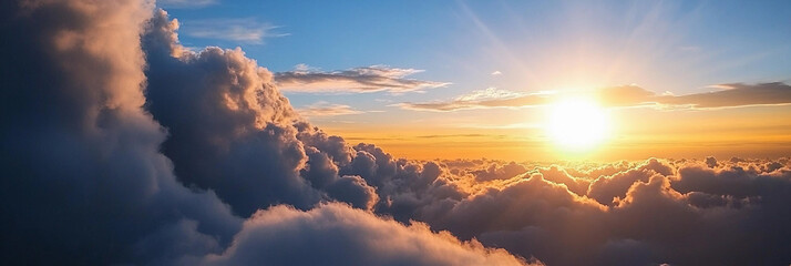 Fototapeta premium Sunrise over fluffy clouds in a clear blue sky