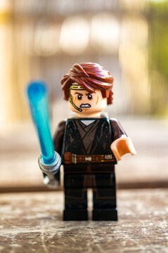 Vertical shot of a Lego Star Wars Anakin Skywalker toy  holding a blue laser sword