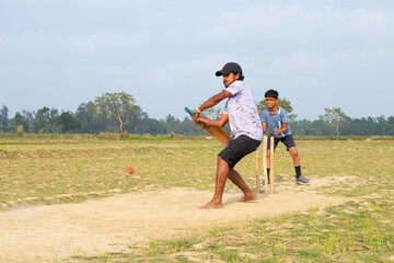 Fototapeta premium Rural boy playing cricket in village located in West bengal, India
