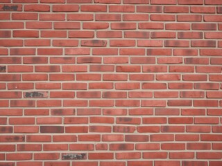 Obraz premium Red brick wall background with rough texture and uneven surface, masonry, surface