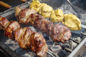 Big fat shish kebab broils in barbecue. Fatty, unhealthy, partially burnt meat