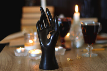 Books, lit candles, red wine, snacks and various deocration on the table. Dark academia or Halloween concept. Selective focus.