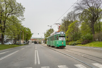 Fototapeta premium Green trolley is traveling down a street