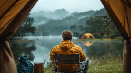 back view of mid south east Asia mid 30's man sitting on chair inside the glamping tent