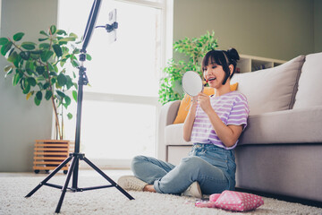 Photo of adorable sweet lady wear violet striped t-shirt applying lip balm recording video modern device indoors room home house