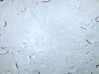 Raindrops sliding on window glass during rainy day