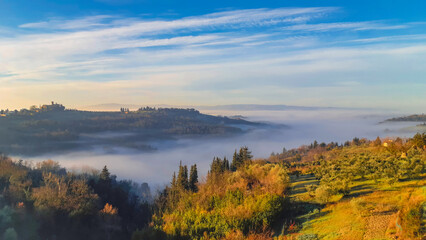 Fog filling val di pesa valley in tuscany, near montespertoli at dawn