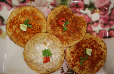 A Popular Rajasthani and Gujarati cuisine 'Khakhra' snack garnished with raw onion, green chili, coriander and sprinkled with sugar and garam masala.