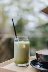 Japanese iced matcha latte, green tea with milk, soy milk, with straw in glass. Outdoor cafe