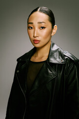 Asian woman black leather jacket posing for camera gray background fashion style portrait model...