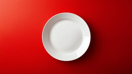 A white plate on a red background.