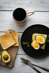 
Sandwiches with avocado, tomatoes and poached eggs. on a wooden backyard. Snidanok.