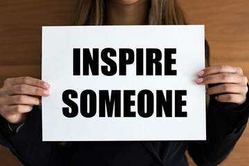 Inspire someone. Woman with white page, black letters. Advice, encouragement, inspiration, motivation.