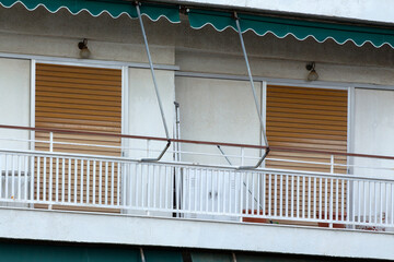 close up on the facade of an apartment building in Athens, Greece with green awnings and brown shutters