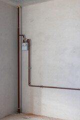 Gas counter with gas pipes in a corner of new unfinished apartment or house.