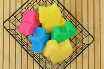 Baby washcloths in a metal basket on a wooden background. Baby care and hygiene. Wash and cleaning. Top view.