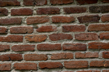 Antique clay brick wall with gray cement lines. Concept: Bricks, wall, vintage, background, industrial.