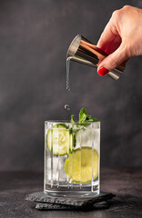 Drink photography of cocktail with lime, cucumber and mint, gin and tonic, shot, jigger, mocktail; mojito; rum; beverage; drink; celebration; party; celebration