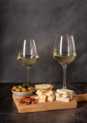 Food photography of white wine with goat gouda cheese, parmesan, olives, pecan, crackers, french meal, winery, assortment, snack for a couple