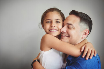 Fototapeta premium Smile, father and daughter hug with love for affection, security and bonding together of relationship. Happy, girl and man with embracing for care, comfort and family connection on studio background
