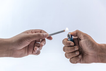 The hand is lighting a cigarette on a white background.