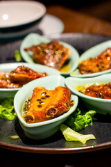 several small bowls of food including meat, cheese, and vegetables.