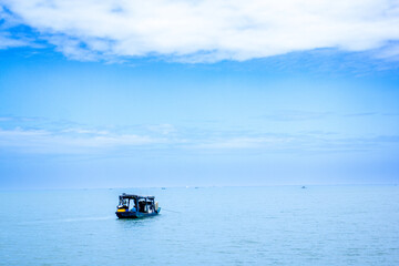 a boat with a blue sky and clouds in the background.