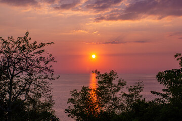 a sunset is seen from the top of a hill.