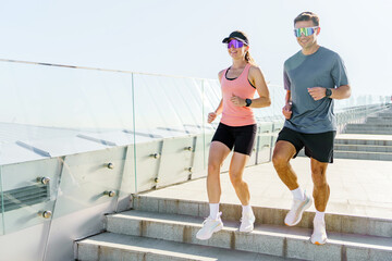 Running Couple Exercising Together on a Sunny Day at a Modern Urban Stairway