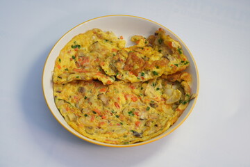 A favorite food for Thai people is omelet with shrimp, fresh mushrooms and chopped carrots.