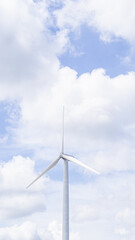 Fototapeta premium Wind turbines and bright sky in vertical image with space for text above.