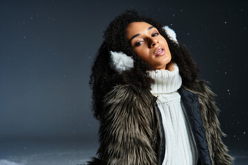 A beautiful brunette woman wears earmuffs and a faux fur jacket, embodying winter fashion in a...