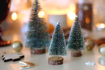 Various Christmas decorations, cookies, chocolate, nuts and tangerines, wine glasses and lit candles on the table. Holiday hygge at home. Selective focus.