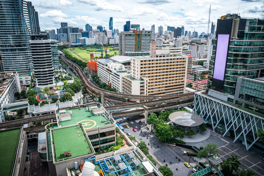 Bangkok Aerial Skyline and Skytrain view of Thailand. Business and financial building area centers with smart green park among urban city at noon time.