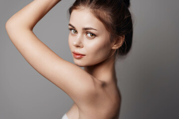 Naklejka premium Beautiful young woman with towel around her neck posing for the camera with hands on head