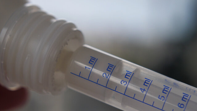 Close up of measuring antibiotics dosage with a transparent syringe
