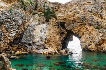 Majestic Rocky Cave with Clear Turquoise Waters and Natural Beauty..