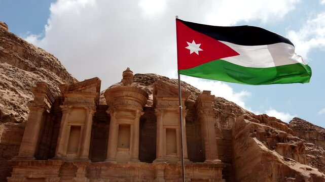 The jordanian flag waves in the wind in front of the treasury at petra, a unesco world heritage site