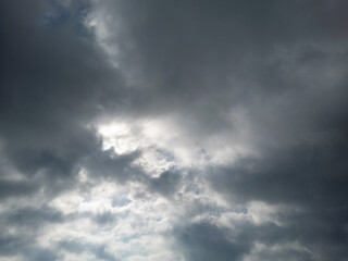 A dramatic dark, stormy sky and a ray of light piercing through the clouds