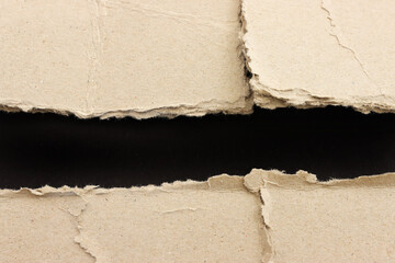 Black torn paper on brown background