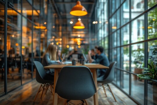 Business people working together in a luminous, modern open plan office, using laptops, sitting at a wooden table, collaborating on a project