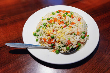 Mixed rice with colorful vegetables in a white plate on the table
