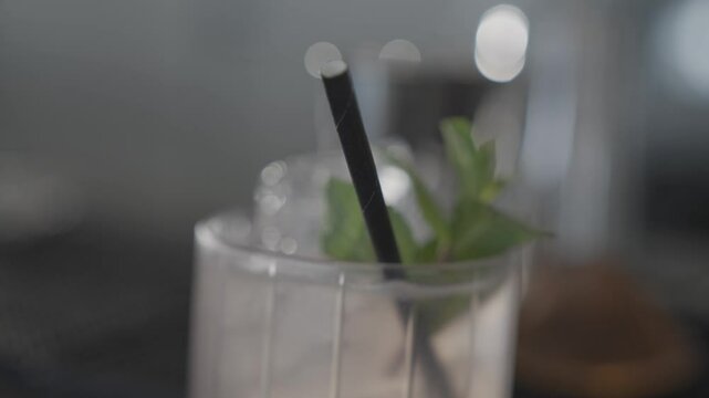 Close up shot of a glass of cocktail and a straw in it