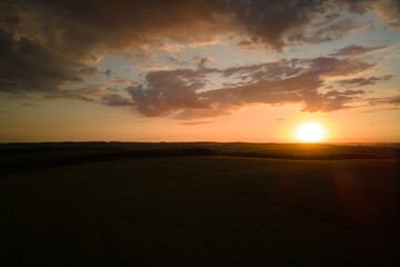 Aerial landscape view of yellow cultivated agricultural field with ripe wheat on vibrant summer evening