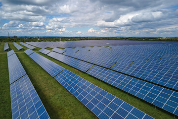 Aerial view of large sustainable electrical power plant with rows of solar photovoltaic panels for...