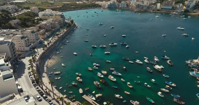 Aerial view of Bugibba on the island of Malta. Seascape of a marina and urban landscape of a tourist city in the Mediterranean, tourism and travel weekend. High quality 4k footage