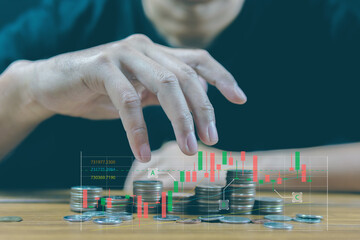 Concept of profitable investment, man use his hand to make a magic gesture to increase the return on the coin, bar chart on stacked coins.