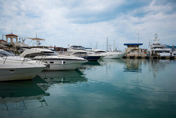 Fototapeta premium Yacht club and marina long view. Luxurious yacht marina. Yacht parking in harbor, harbor yacht club Beautiful Yachts in blue sky background.